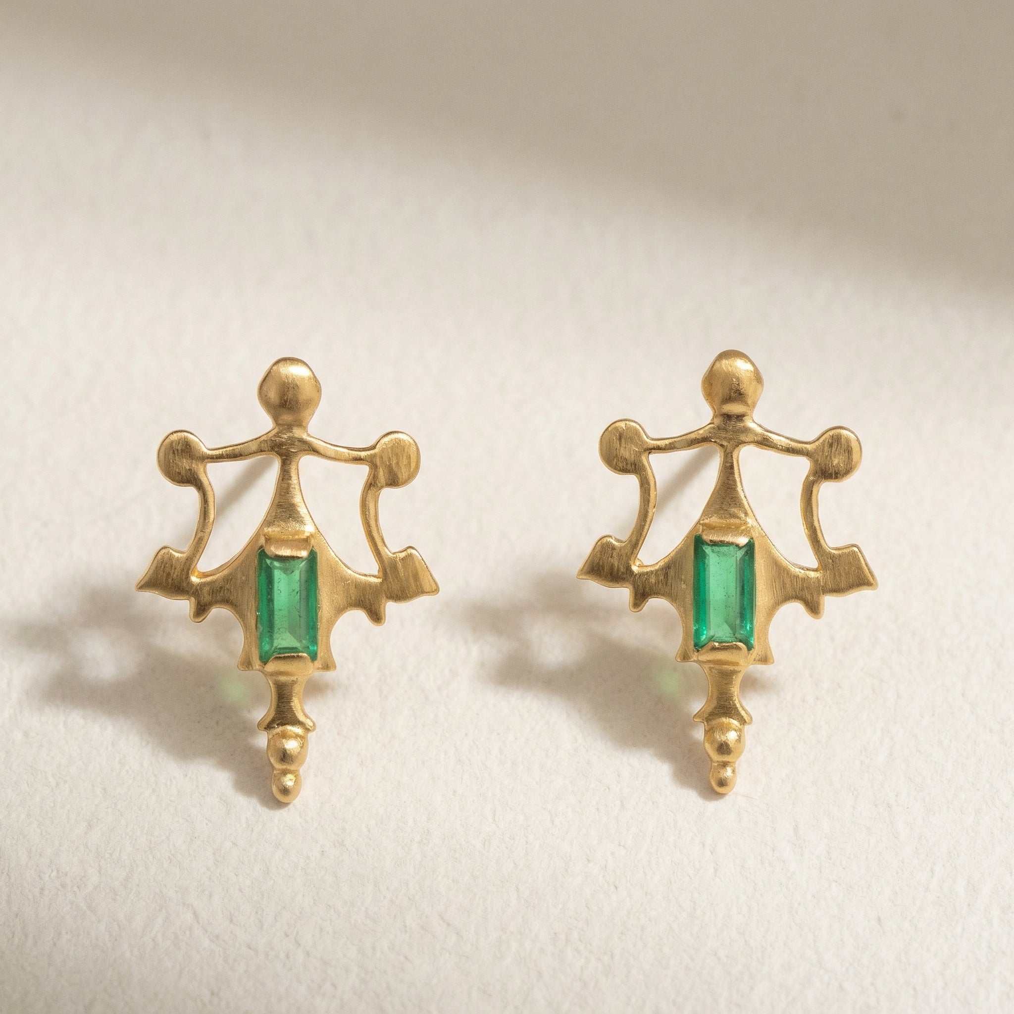 Close-up of the hand-cast ancient artifact detail and green baguette stone accent.