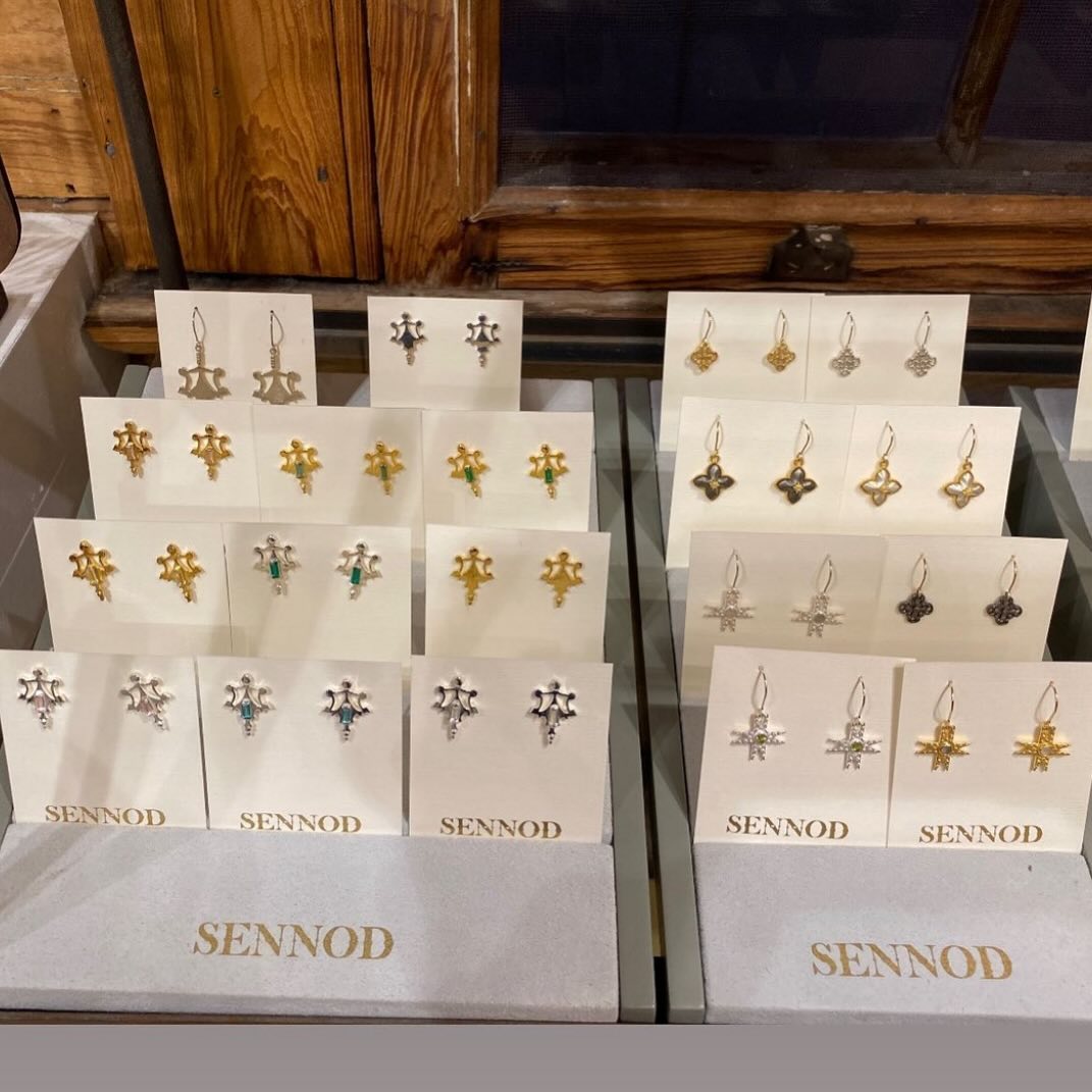 Sennod Jewelry display featuring gold earrings, silver earrings, studs, and statement earring designs in elegant handcrafted styles.